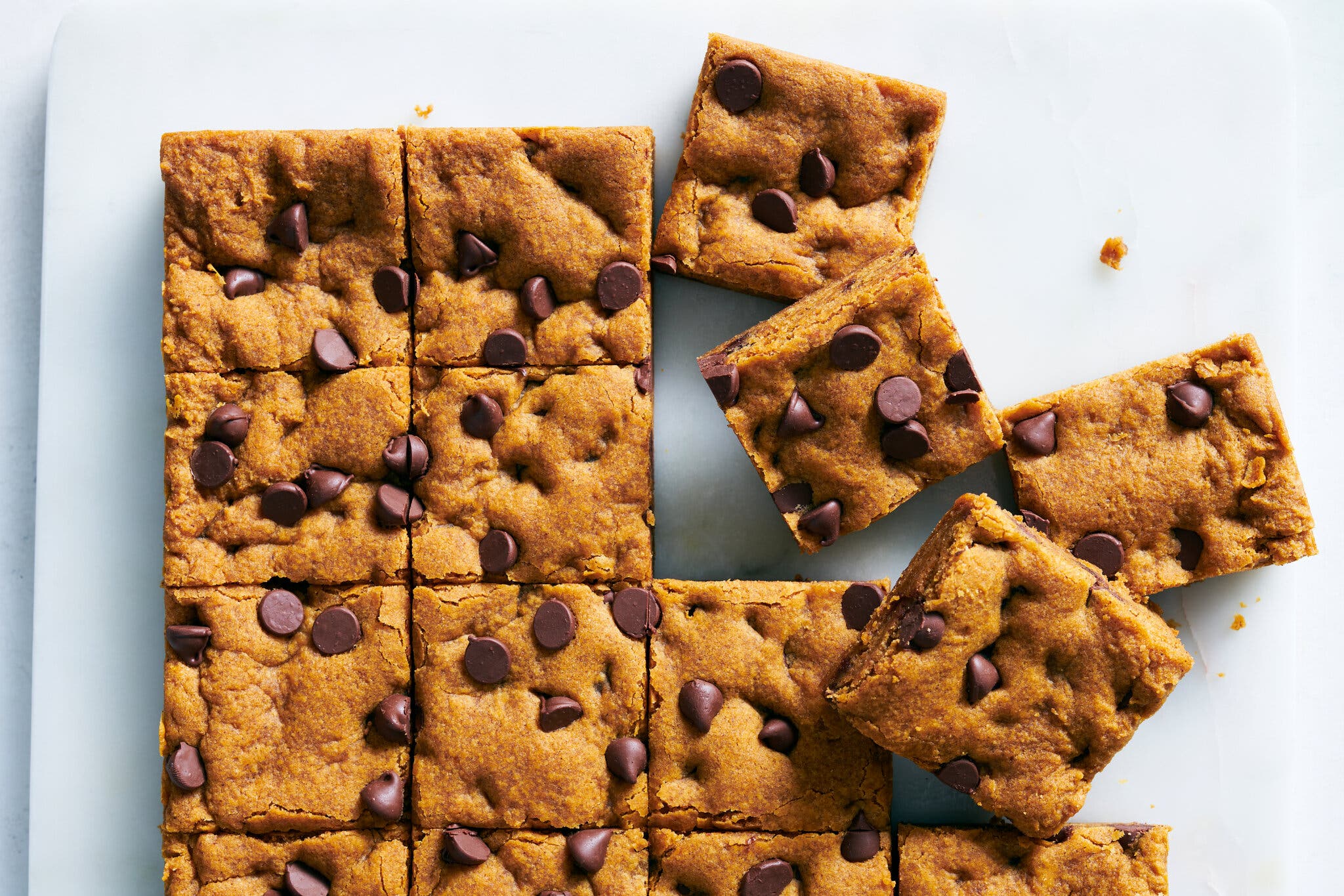 An overhead image of pumpkin bars topped with chocolate chips and cut into squares.